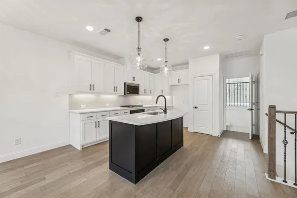 a kitchen with stainless steel appliances granite countertop a sink stove and wooden floor