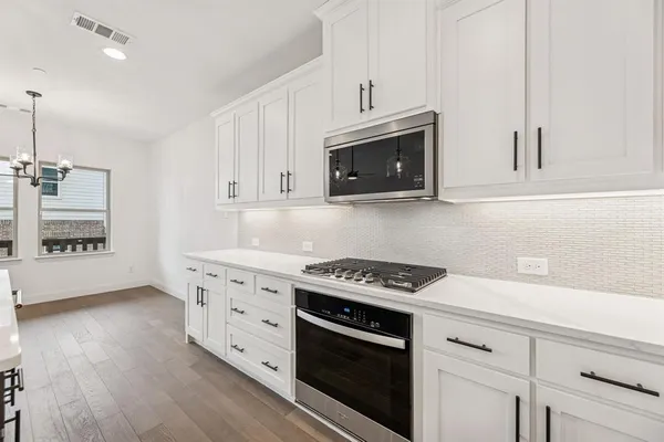 a kitchen with stainless steel appliances granite countertop a sink a stove and a microwave