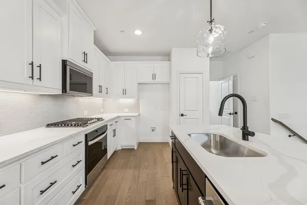 a kitchen with stainless steel appliances granite countertop a sink a stove and a refrigerator