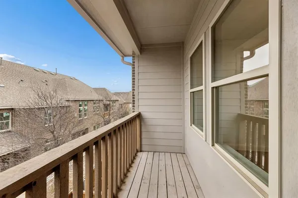 a view of a balcony with wooden floor and fence