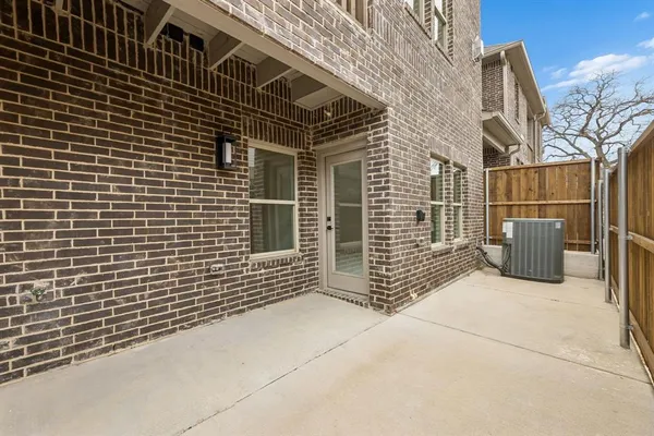 a view of a brick house with wooden fence