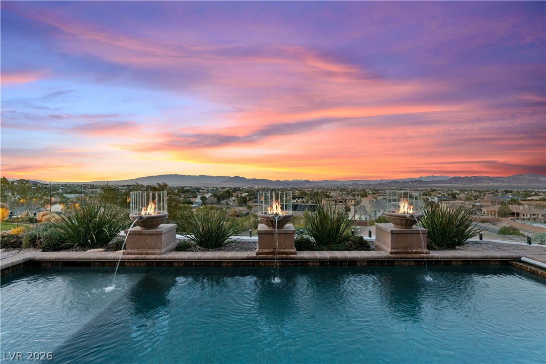 A desert oasis, featuring a glistening pool and a panoramic sunset vista.