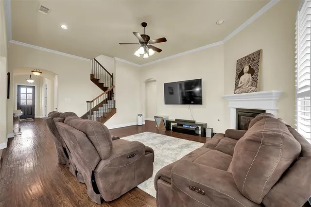 a large living room with stainless steel appliances granite countertop couches a fireplace a flat screen tv and a kitchen island