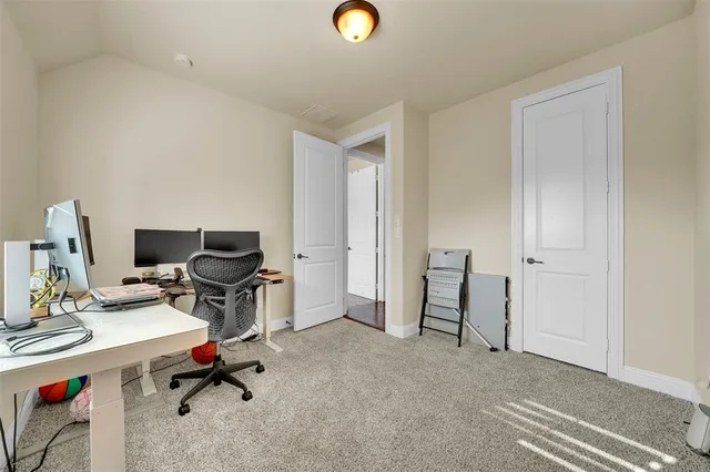 a view of a workspace with furniture and a window