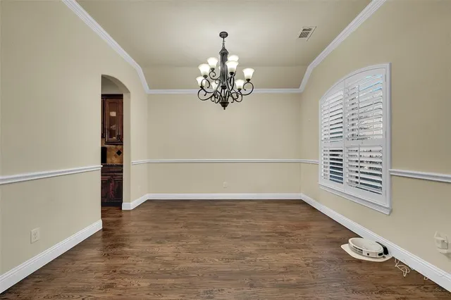 a view of a livingroom with wooden floor and a chandelier