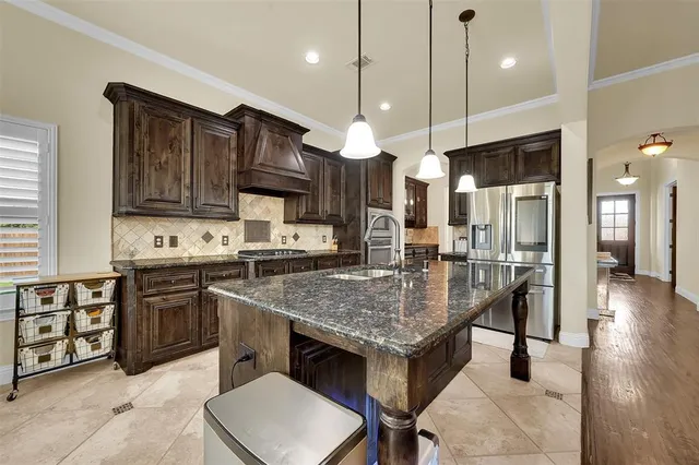 a kitchen with stainless steel appliances granite countertop a stove refrigerator and cabinets