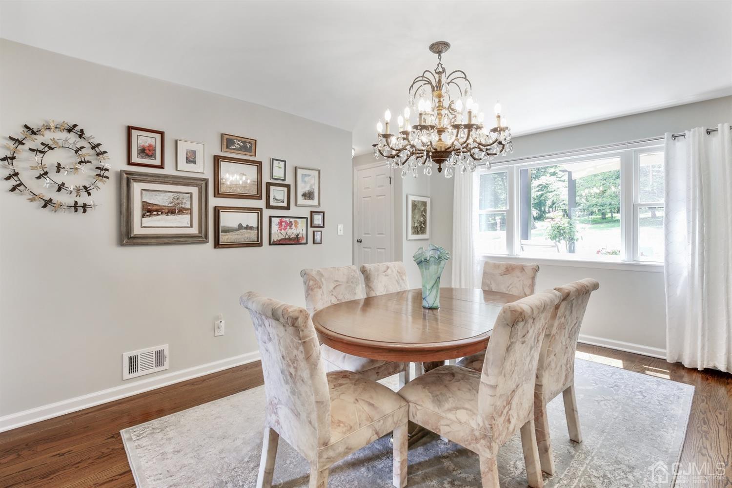 971 Carteret Road Bridgewater, NJ 08807 - Photo 8 of 27 a dining room with wooden floor a chandelier a wooden table and chairs