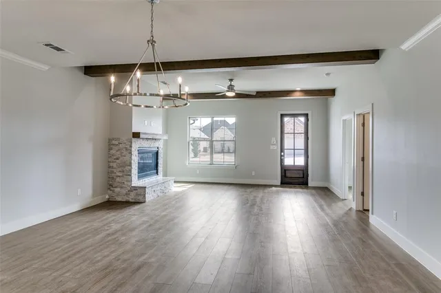 a view of a room with wooden floor a ceiling fan and window