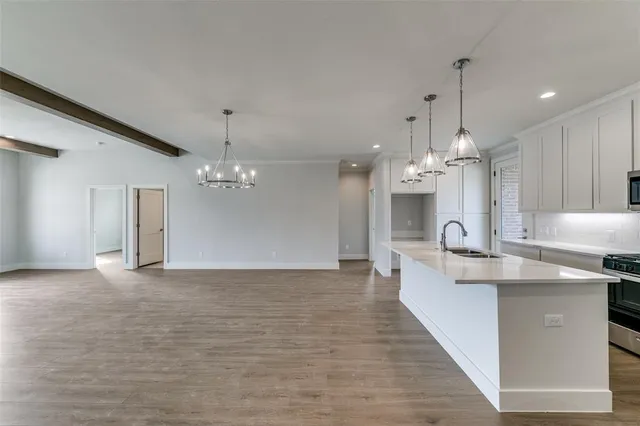a view of a kitchen with kitchen island a chandelier and wooden floor