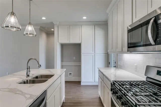 a kitchen with stainless steel appliances granite countertop a sink and a stove top oven