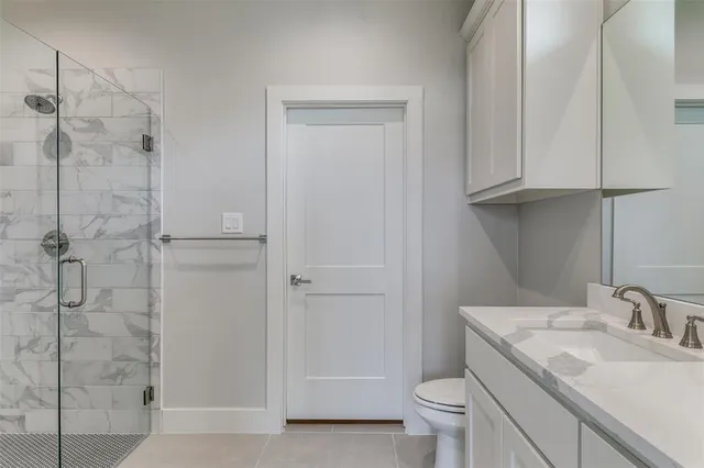 a bathroom with a granite countertop sink a toilet and shower