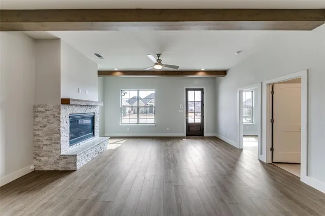 a view of a livingroom with wooden floor a fireplace and window