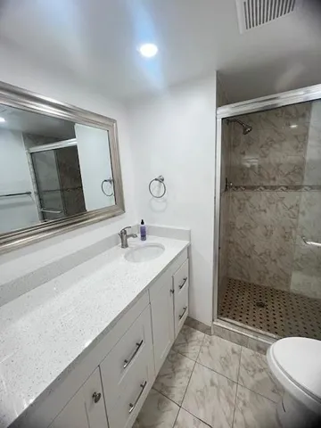 a bathroom with a sink toilet vanity and shower