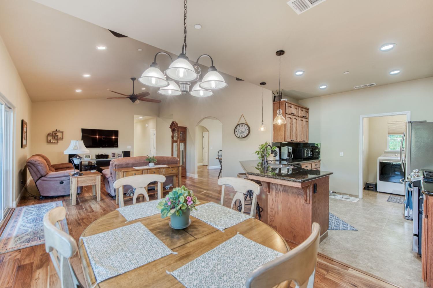 20431 Thermal Road Sanger, CA 93657 - Photo 13 of 88 a view of a dining room and livingroom with furniture a rug a fireplace and a chandelier