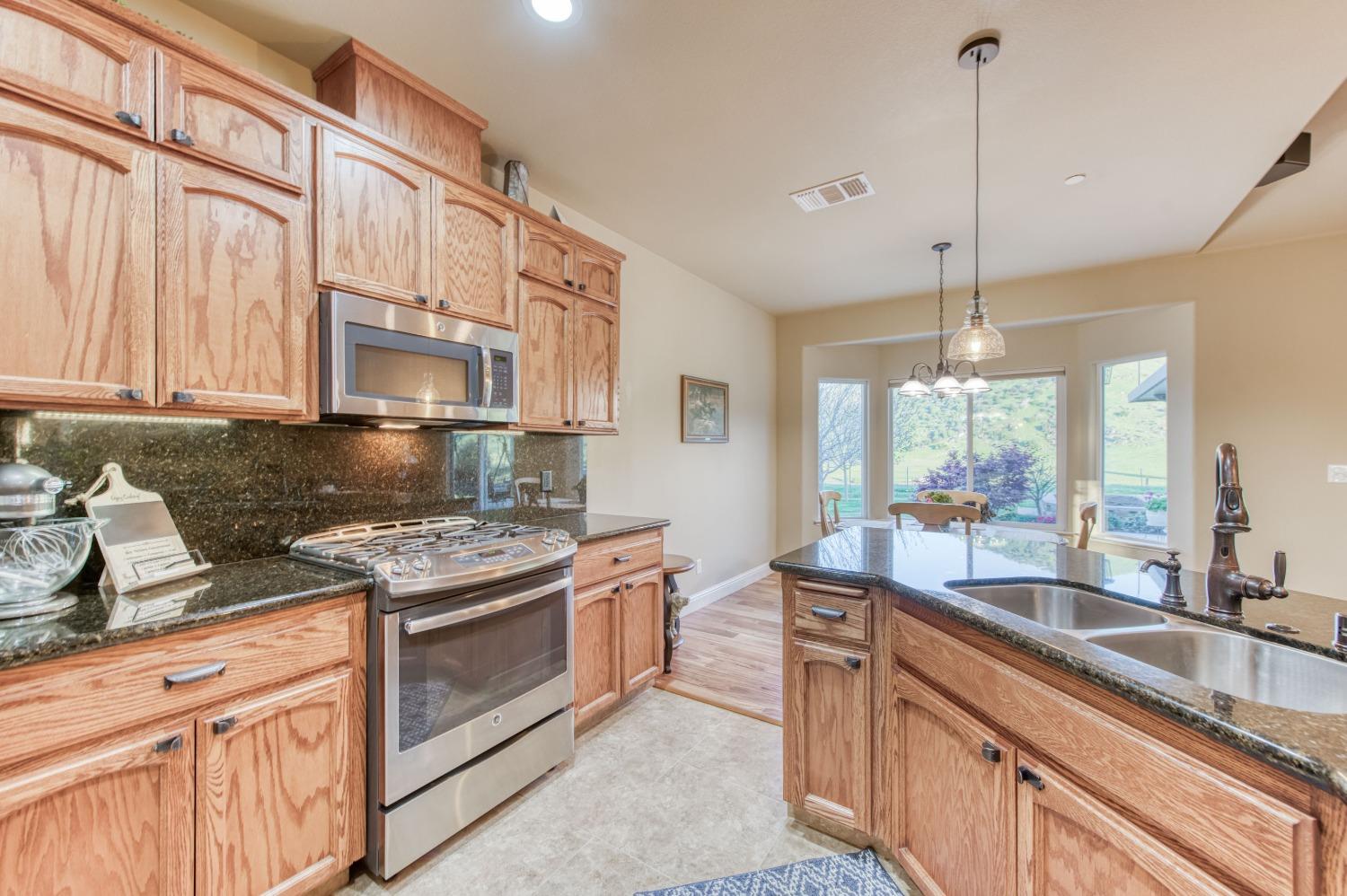 20431 Thermal Road Sanger, CA 93657 - Photo 16 of 88 a kitchen with stainless steel appliances granite countertop a stove a sink and a granite counter tops