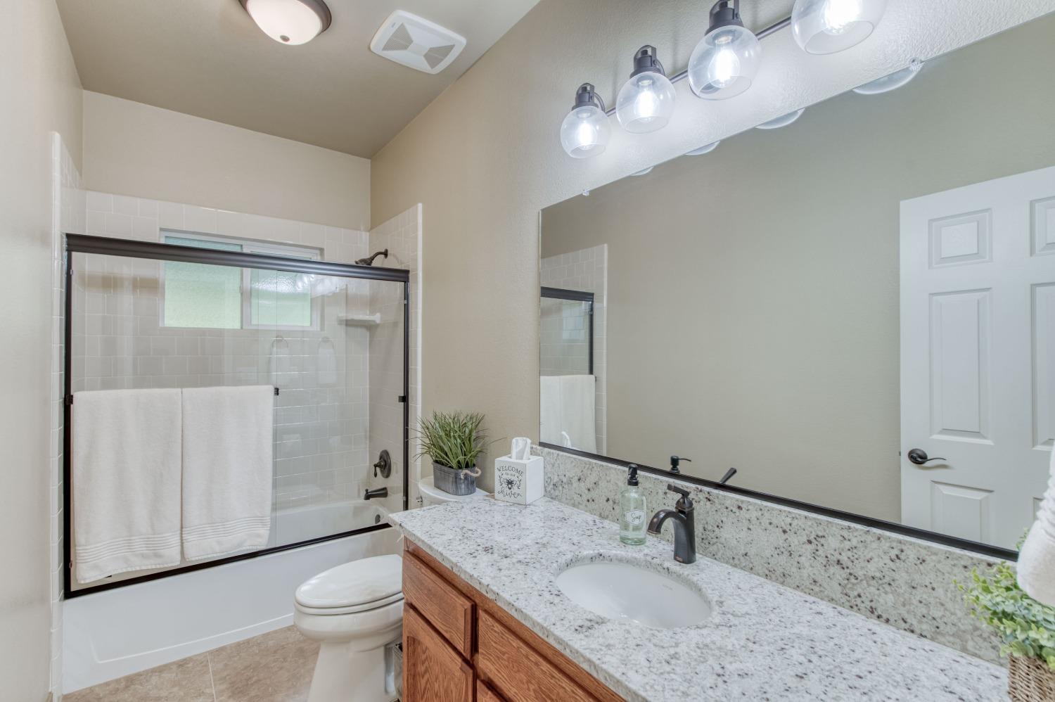 20431 Thermal Road Sanger, CA 93657 - Photo 28 of 88 a bathroom with a granite countertop sink a toilet and shower