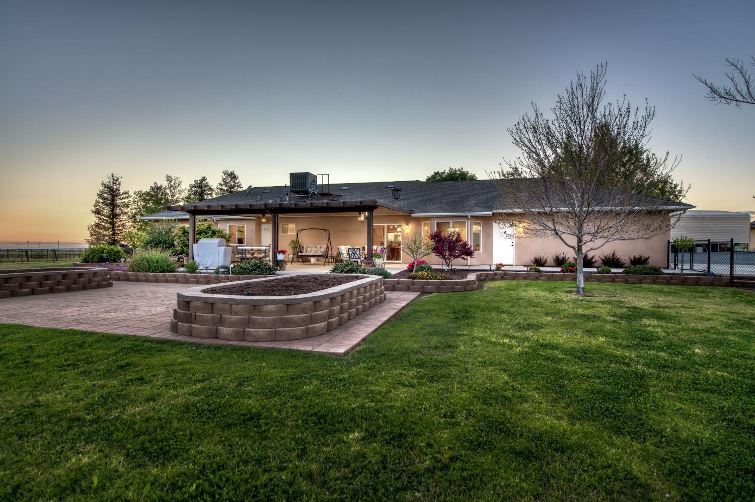 20431 Thermal Road Sanger, CA 93657 - Photo 37 of 88 a front view of a house with garden and sitting area