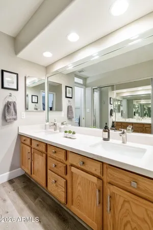 a bathroom with double vanity a mirror and a sink