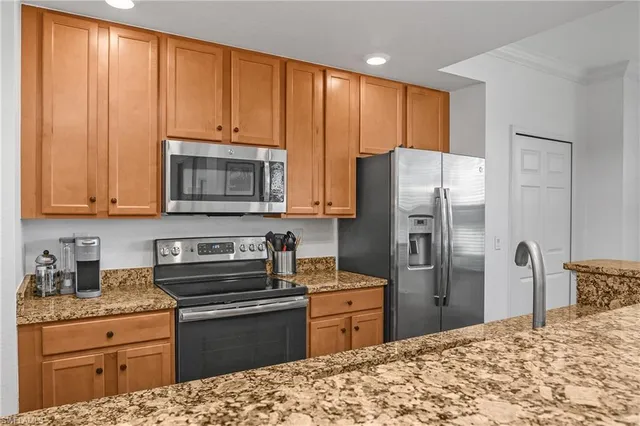 a kitchen with granite countertop wooden cabinets and stainless steel appliances