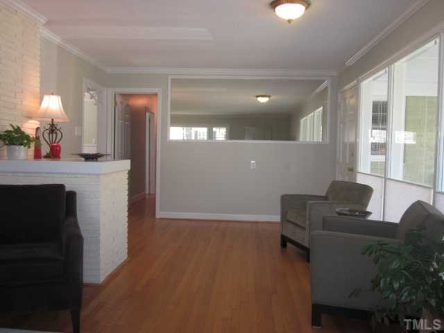 2031 Reaves Drive Raleigh, NC 27608 - Photo 24 of 25 Here is the dining room area! Dining room features a new light, wainscoting & brick knee wall! Very open floor plan between dining and living room areas! Beautiful refinished hardwood floors! Dining Room