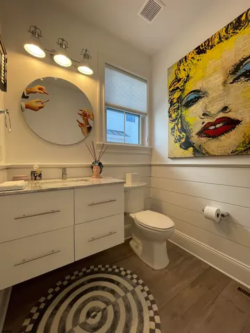 a bathroom with a toilet a sink and mirror