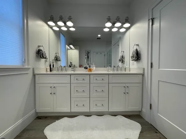 a bathroom with a sink a toilet a mirror and shower