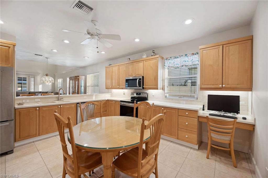 10082 Vanderbilt Drive Naples, FL 34108 - Photo 12 of 43 a kitchen with kitchen island granite countertop wooden cabinets and stainless steel appliances