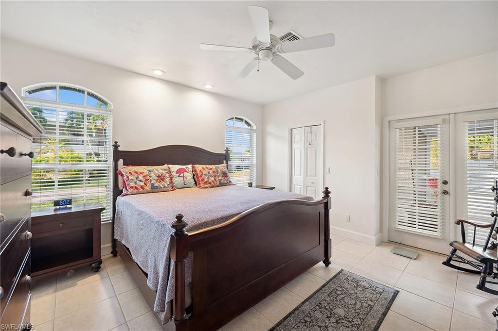 10082 Vanderbilt Drive Naples, FL 34108 - Photo 18 of 43 a bedroom with a bed and wooden floor