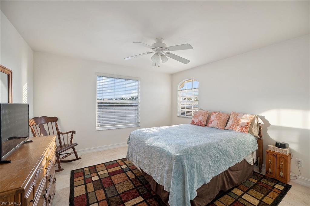 10082 Vanderbilt Drive Naples, FL 34108 - Photo 22 of 43 a bedroom with a bed and a chandelier