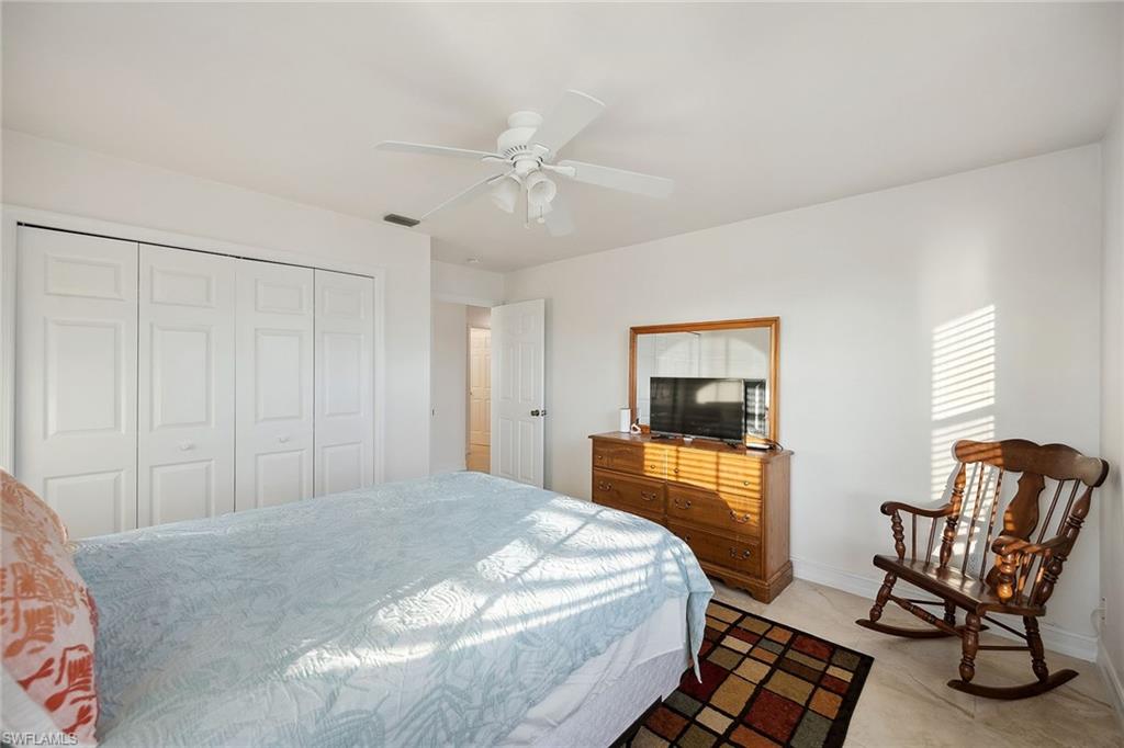 10082 Vanderbilt Drive Naples, FL 34108 - Photo 23 of 43 a bedroom with a bed and chair