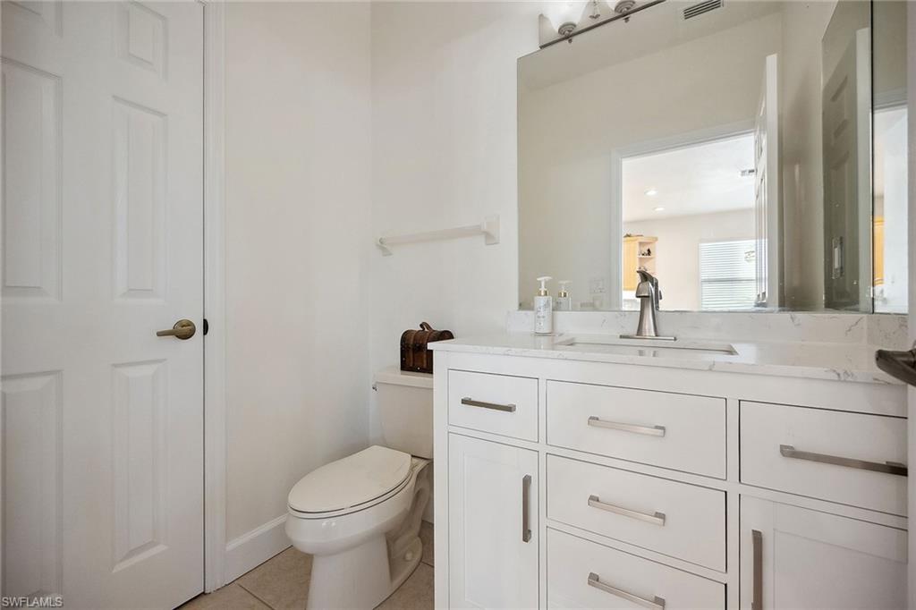 10082 Vanderbilt Drive Naples, FL 34108 - Photo 26 of 43 a bathroom with a granite countertop toilet sink and mirror