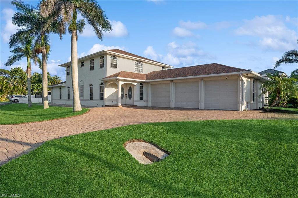 10082 Vanderbilt Drive Naples, FL 34108 - Photo 34 of 43 a front view of a house with a garden and yard