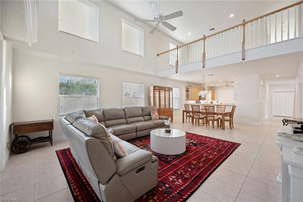 10082 Vanderbilt Drive Naples, FL 34108 - Photo 8 of 43 a living room with furniture a rug and white walls