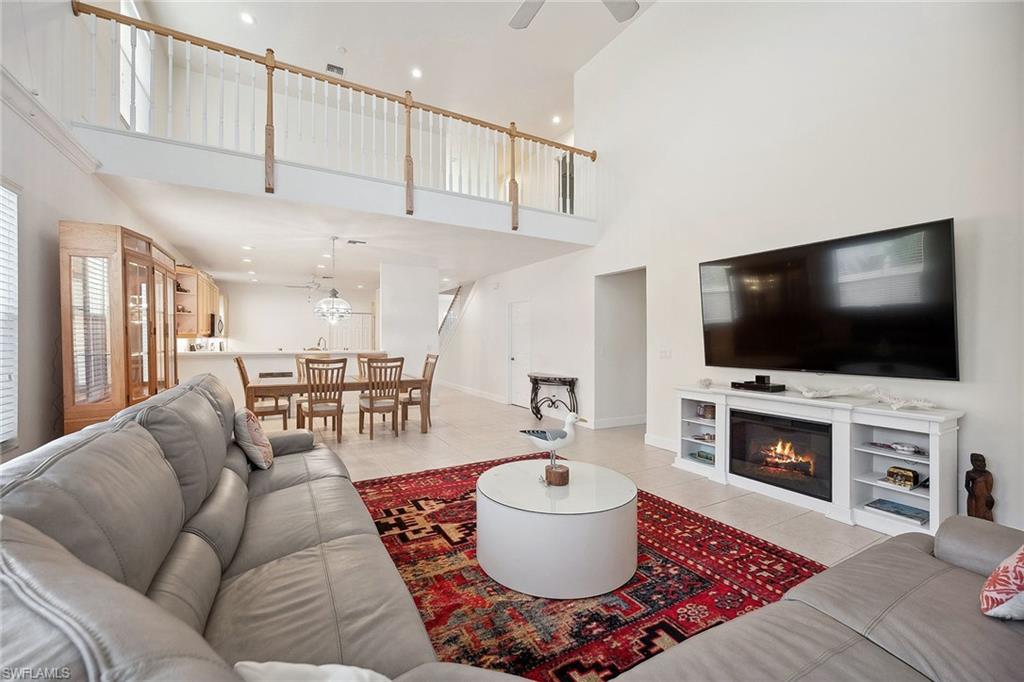 10082 Vanderbilt Drive Naples, FL 34108 - Photo 9 of 43 a living room with furniture and a flat screen tv