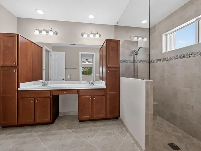 a view of an empty room with window and a chandelier fan