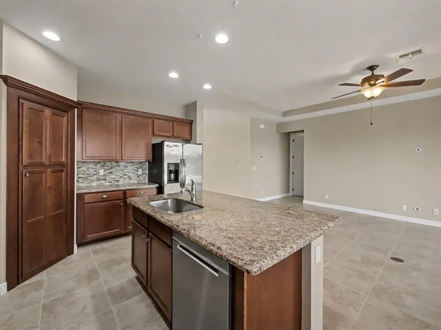 an empty room with windows and ceiling fan