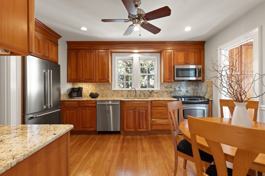 2 Plymouth Road Lexington, MA 02421 - Photo 6 of 38 a kitchen with stainless steel appliances granite countertop a refrigerator a sink dishwasher a stove and white countertops with wooden floor