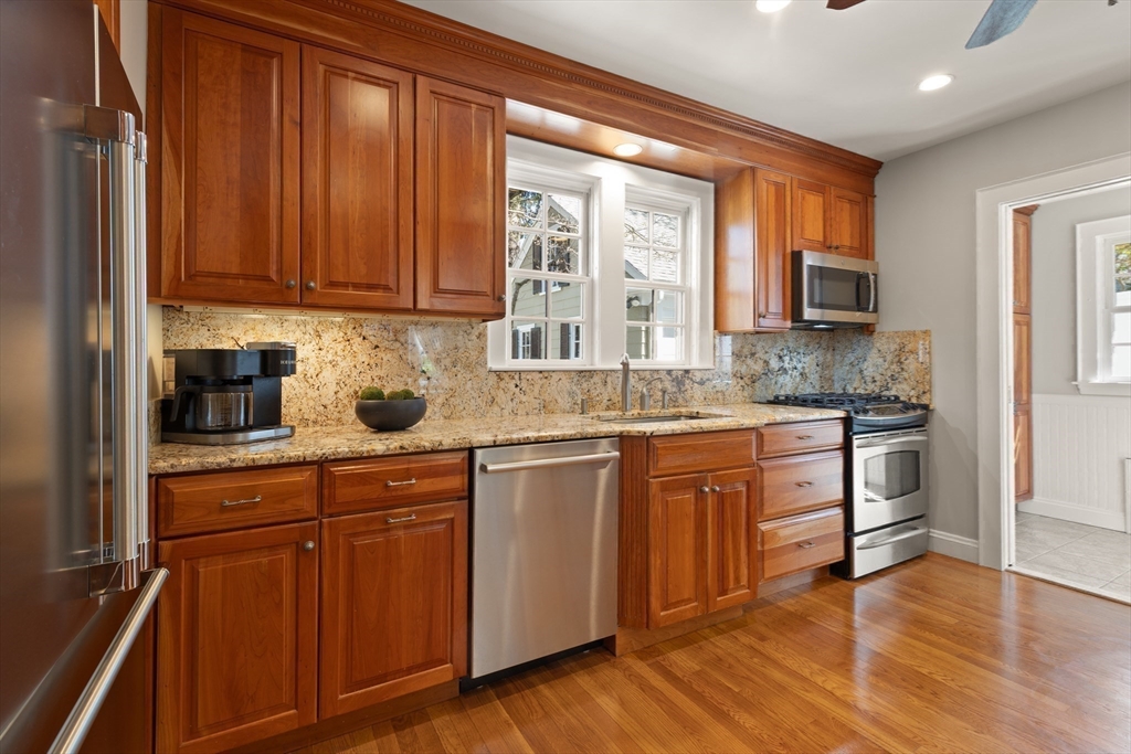 2 Plymouth Road Lexington, MA 02421 - Photo 7 of 38 a kitchen with stainless steel appliances granite countertop wooden cabinets a sink and dishwasher with wooden floor