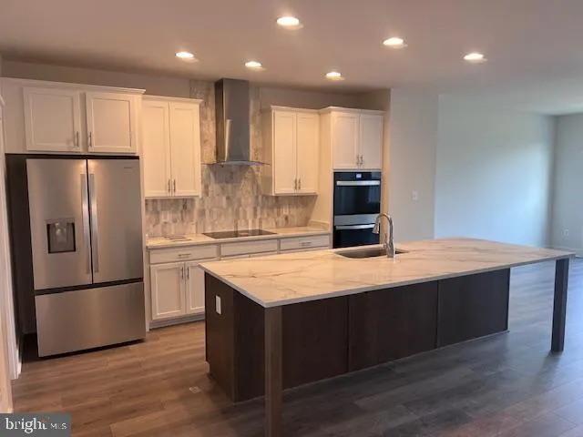 a kitchen with stainless steel appliances granite countertop a refrigerator a sink and a stove