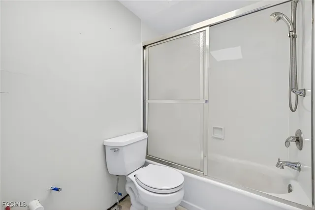 a white toilet sitting next to a bath tub