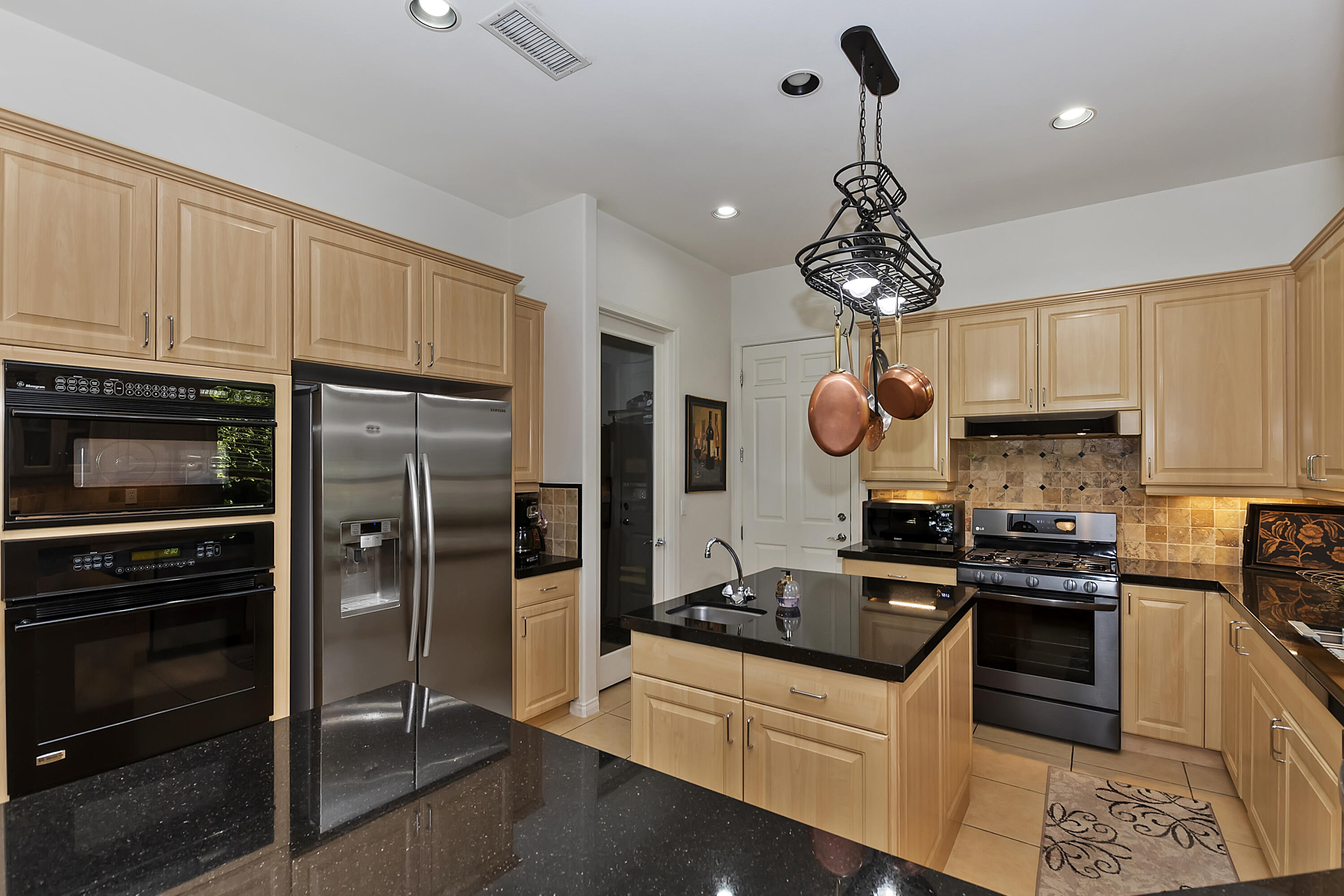 60 Victor Hugo Road Rancho Mirage, CA 92270 - Photo 20 of 44 a kitchen with stainless steel appliances granite countertop a sink a stove a refrigerator cabinets and chairs