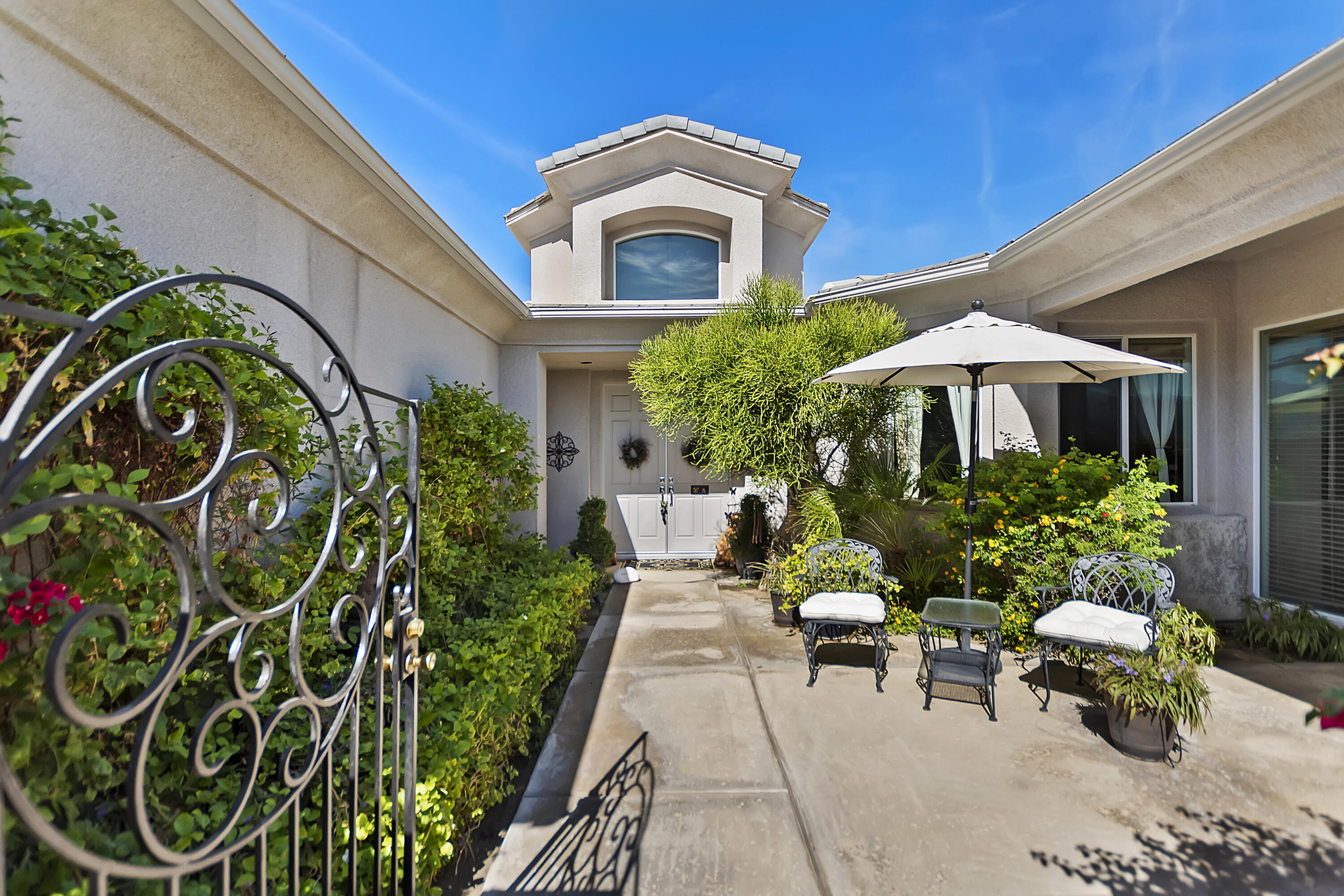 60 Victor Hugo Road Rancho Mirage, CA 92270 - Photo 2 of 44 a view of a patio with a table and chairs under an umbrella