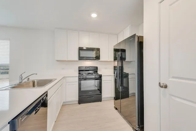a kitchen with stainless steel appliances a refrigerator sink and microwave
