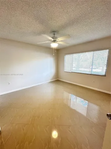 en empty room with windows and ceiling fan view
