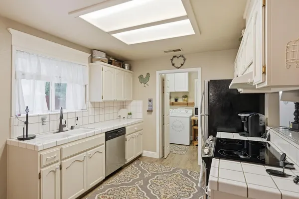 a kitchen with a sink cabinets and refrigerator