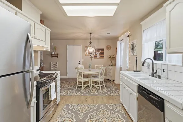 a kitchen with stainless steel appliances kitchen island granite countertop a sink stove and refrigerator