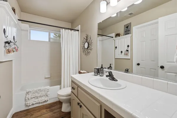 a bathroom with a sink a toilet and shower