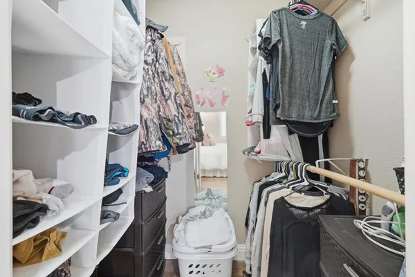 a view of walk in closet with clothes and shoes
