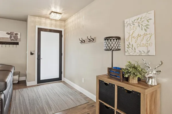 a view of a hallway with wooden floor and a potted plant