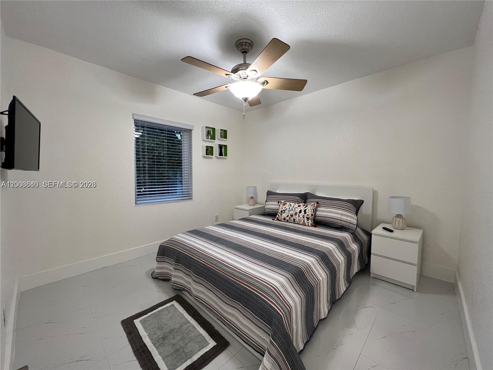 1380 Southwest 11th Street, Unit 1 Miami, FL 33135 - Photo 11 of 20 a bedroom with a bed and a chandelier